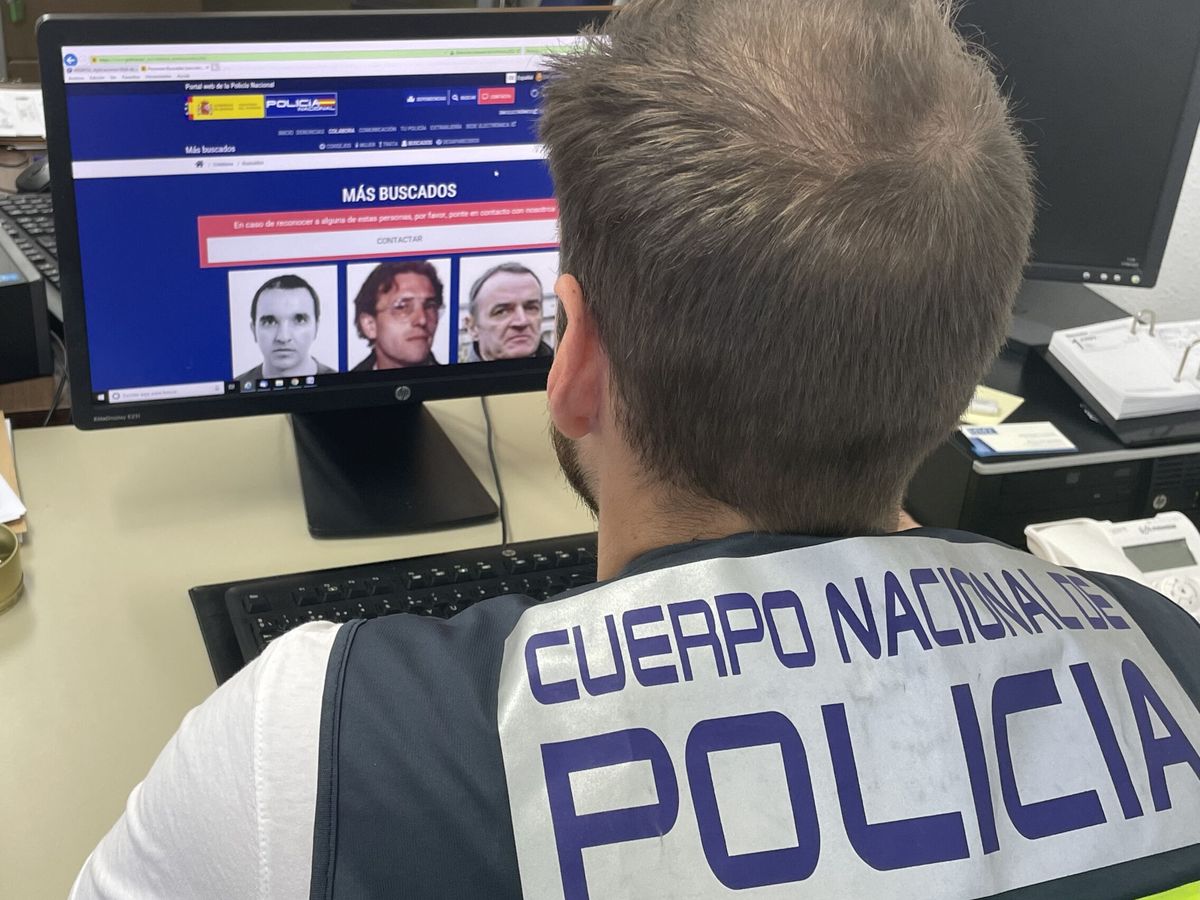 Foto: Un agente de la Policía Nacional ante la lista de los fugitivos más buscados. (EFE/Policía Nacional)