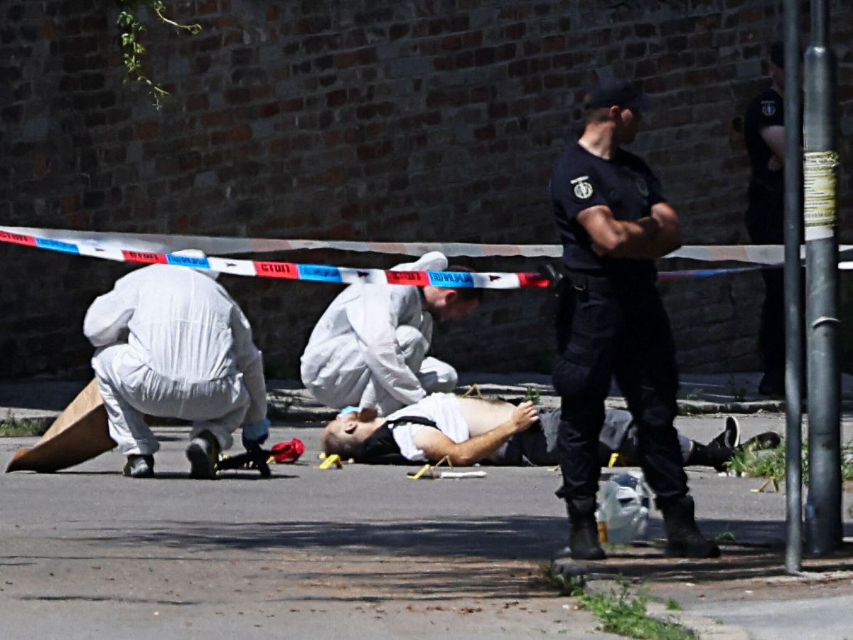 Foto: Un equipo forense trabaja junto al cadáver del atacante de la embajada israelí en Serbia. (Reuters/Zorana Jevtic)
