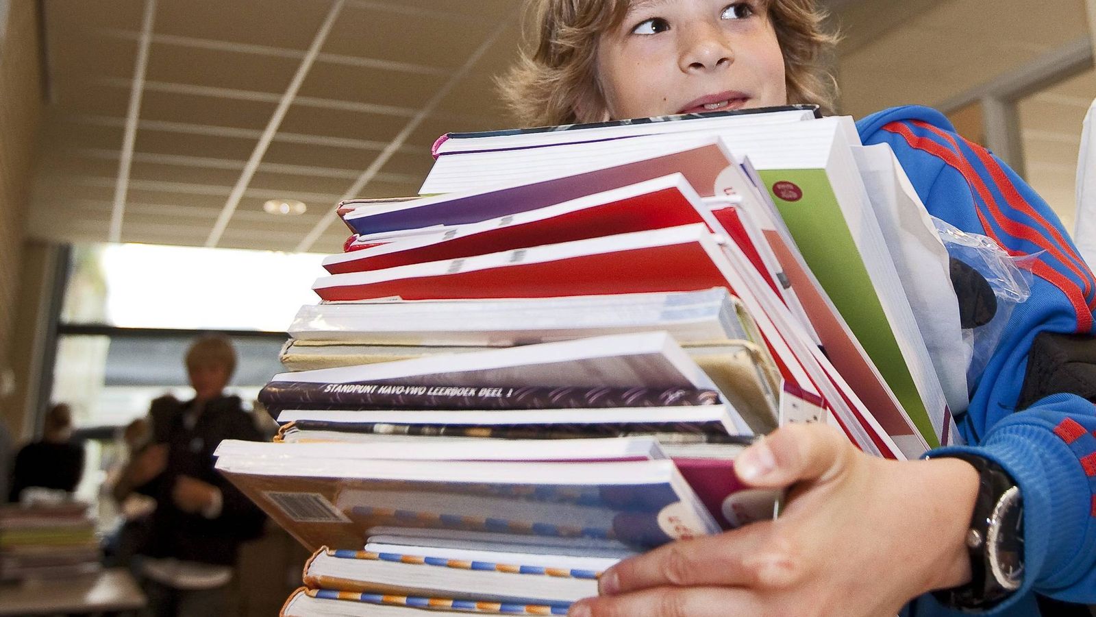 Foto: Un alumno carga con un montón de libros en la 'vuelta al cole'. (EFE)