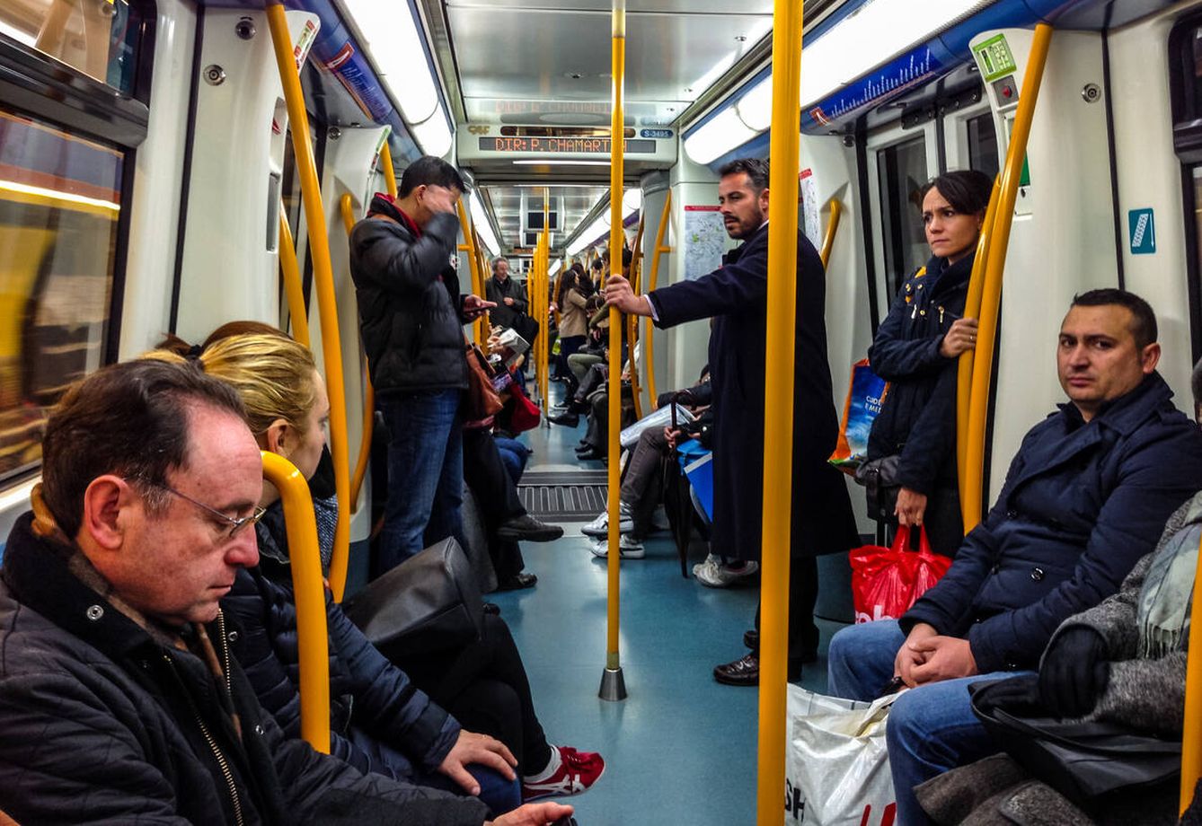 Personas sentadas en el metro de Madrid (iStock)