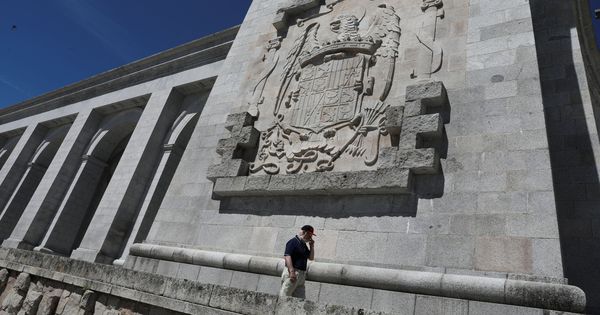 Foto: Un hombre pasea bajo un escudo franquista en el Valle de los Caídos, el pasado 19 de junio. (Reuters)