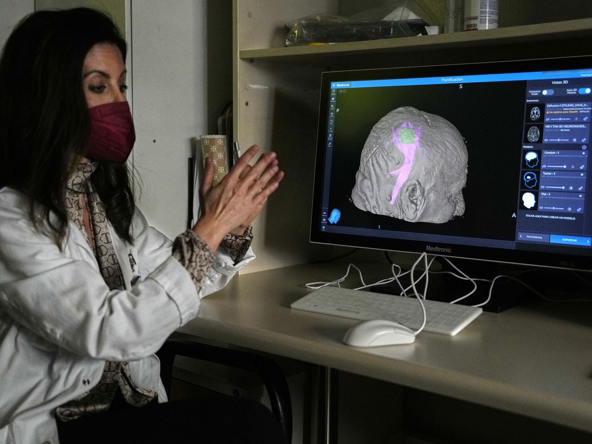 Foto: Una investigadora observa células tumorales en el cerebro (EFE/Alejandro García)