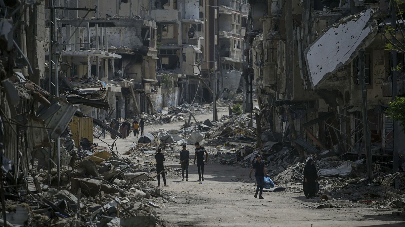 Foto: Varias personas caminan por una zona bombardeada por Israel en Gaza. (EFE/Mohammed Saber)