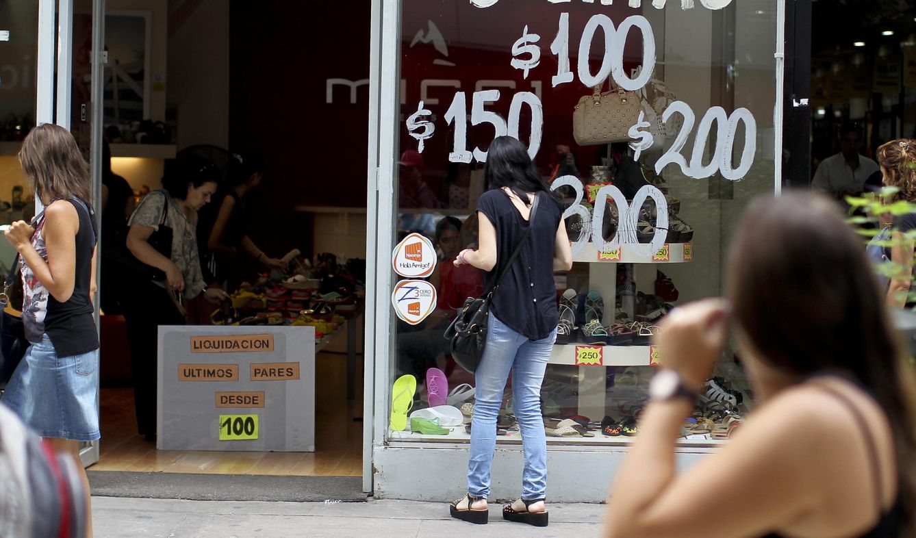 Una mujer observa una vitrina que anuncia ofertas en calzado en Buenos Aires (Argentina). (EFE)