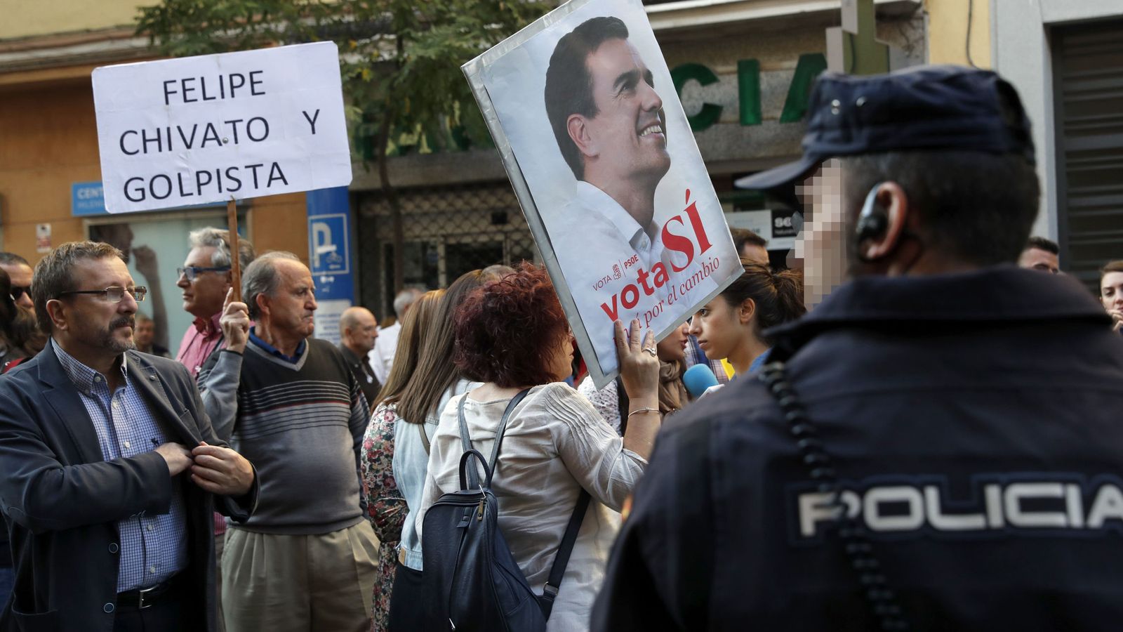 Foto: Dos simpatizantes de Pedro Sánchez con pancartas a las puertas de la sede del PSOE. (EFE)