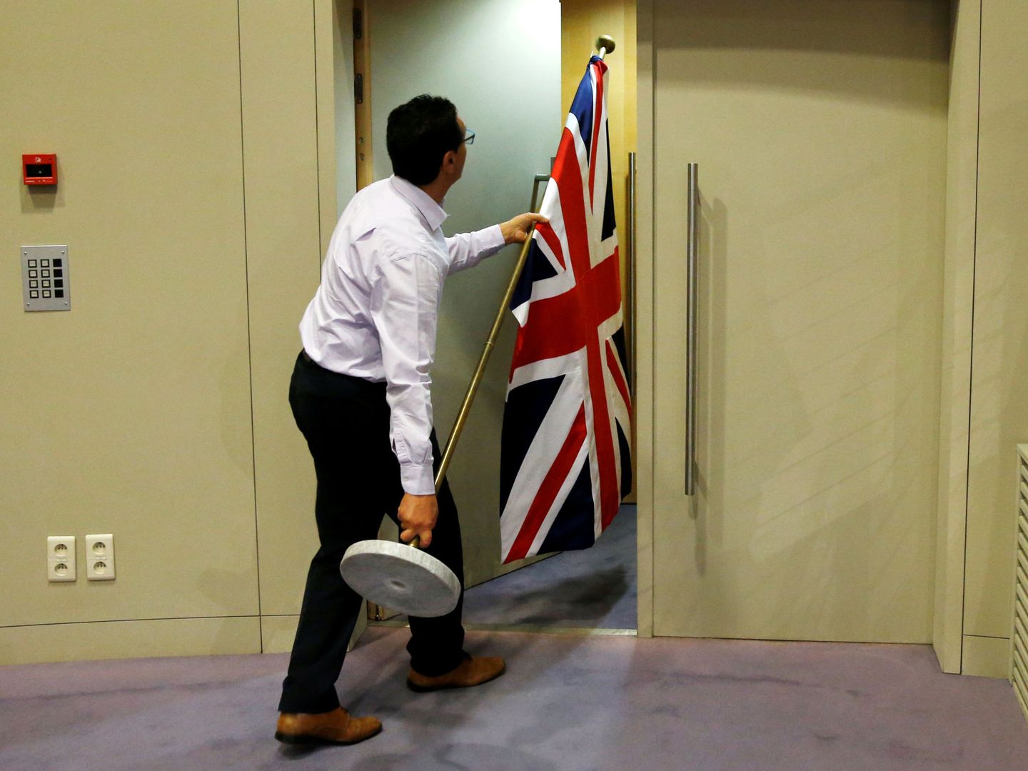 Un trabajador de la Comisión Europea retira una bandera británica. (Reuters)