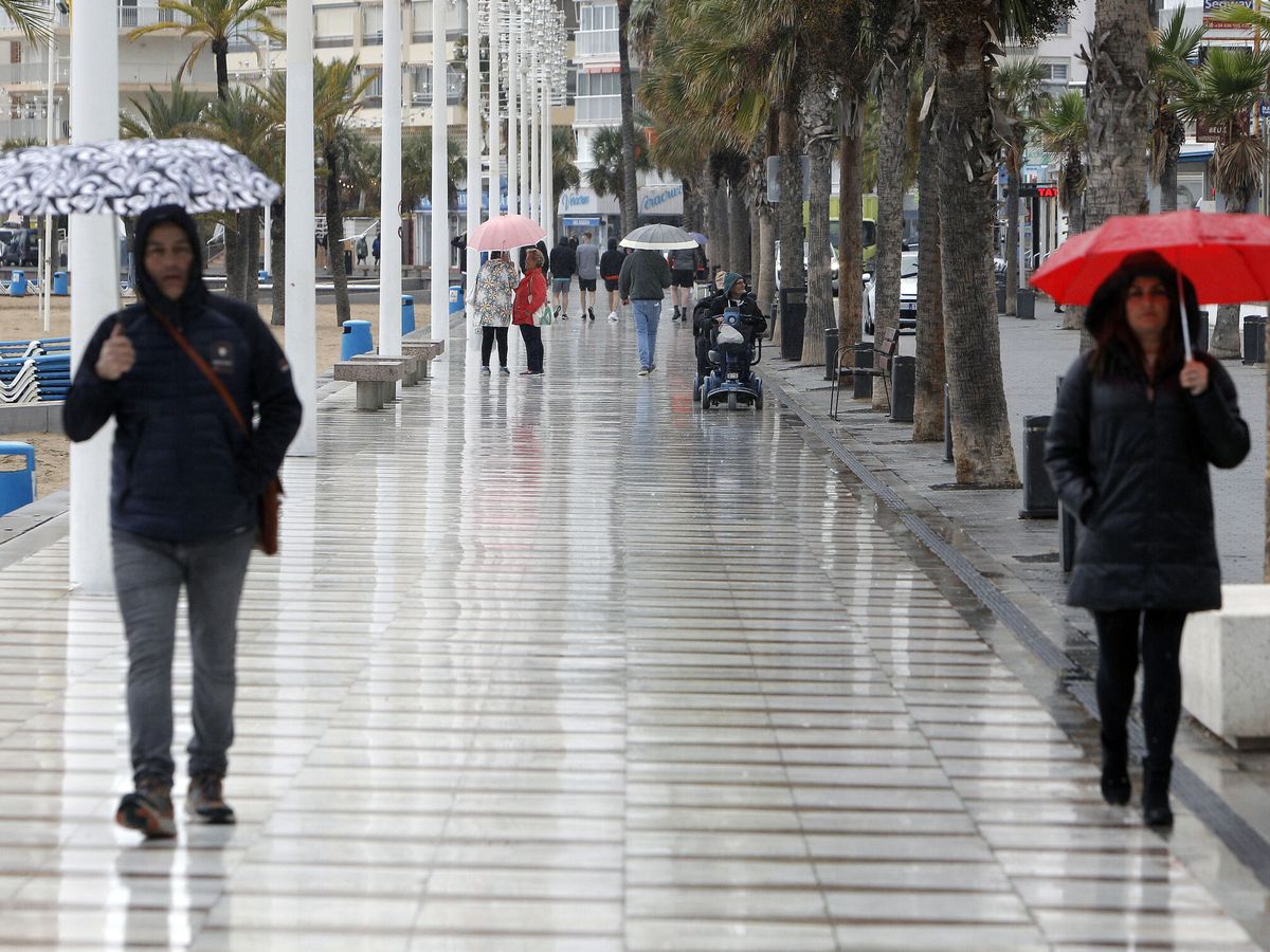 Foto: Dos personas con un paraguas en Benidorm. (EFE/Morell)