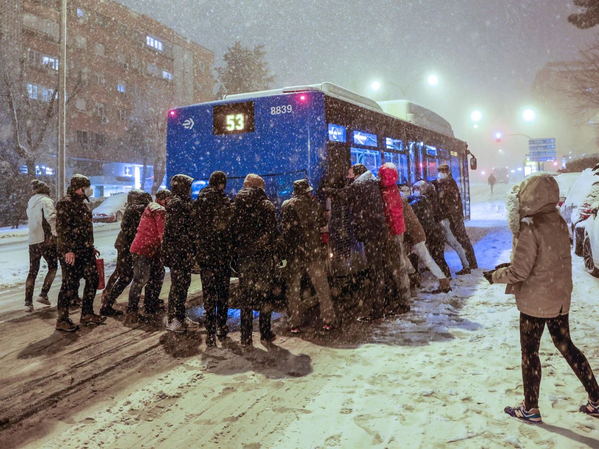 Foto: Varias personas empujan un autobús atascado en la nieve. (EFE)