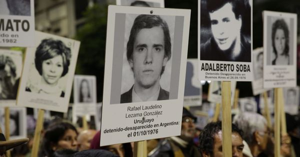 Foto: Manifestantes portan fotografías de detenidos desaparecidos durante la dictadura en una marcha en Montevideo. (EFE)