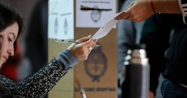 Foto: Un hombre recibe su papeleta electoral este domingo en Buenos Aires (Argentina). (EFE)