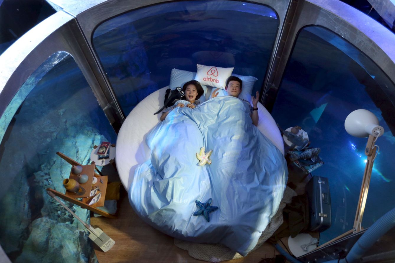 Los ganadores de un concurso de Airbnb durmiendo en una cápsula en el acuario de París (REUTERS)