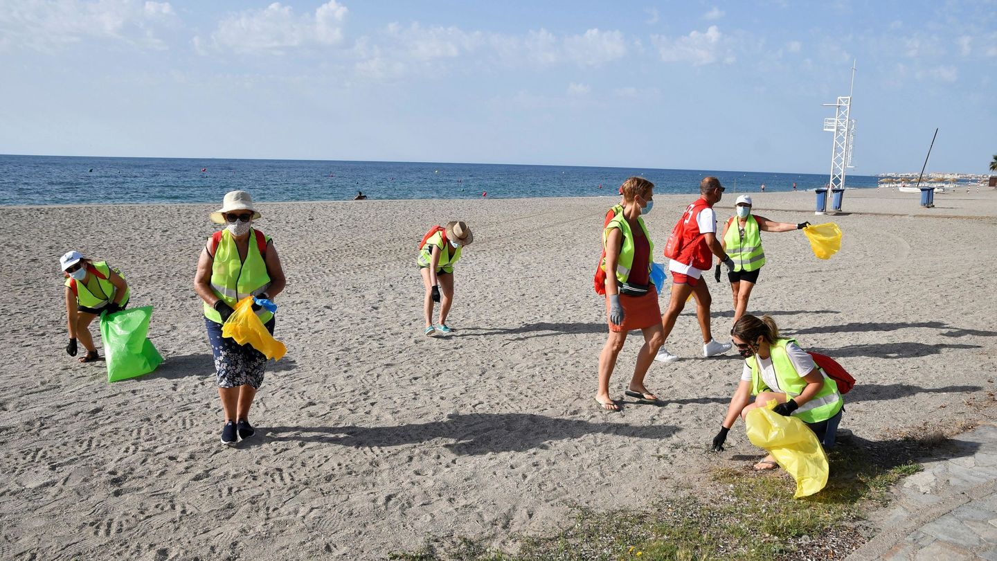 Voluntarios de Libera limpiando una playa de basuraleza (EFE/C.Barba)