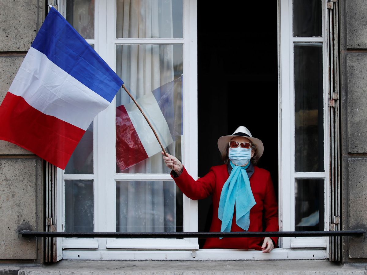 Foto: Una mujer ondea una bandera francesa en Saint-Mande, cerca de París. (Reuters)