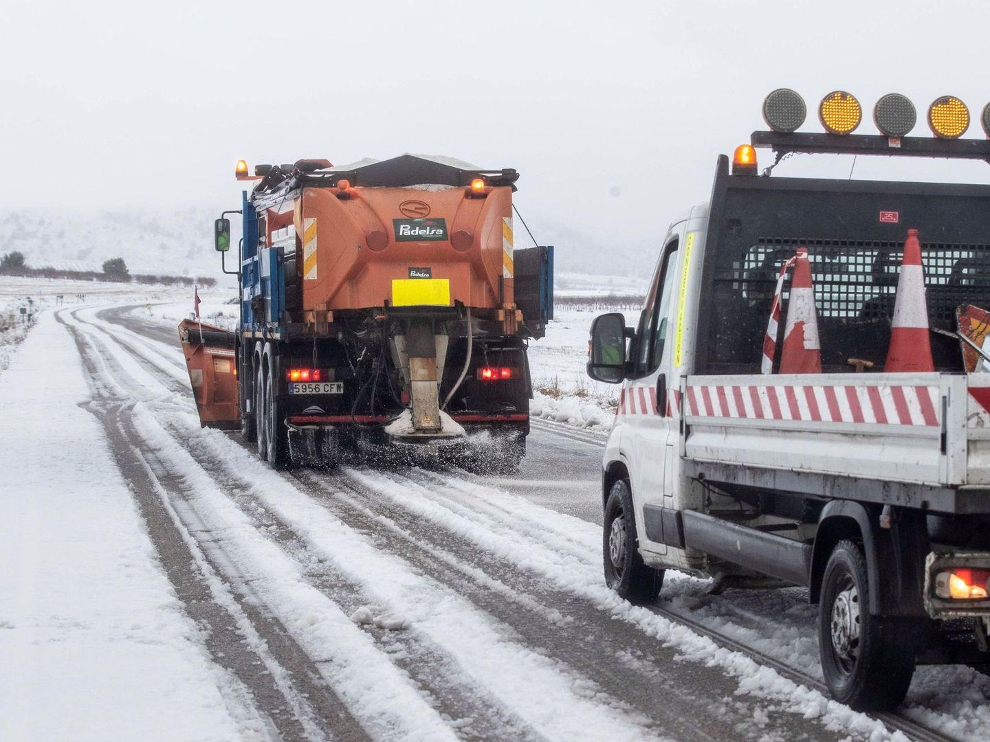 Una máquina quitanieves esparce sal para disolver la nieve de la carretera RM-404. (EFE) 