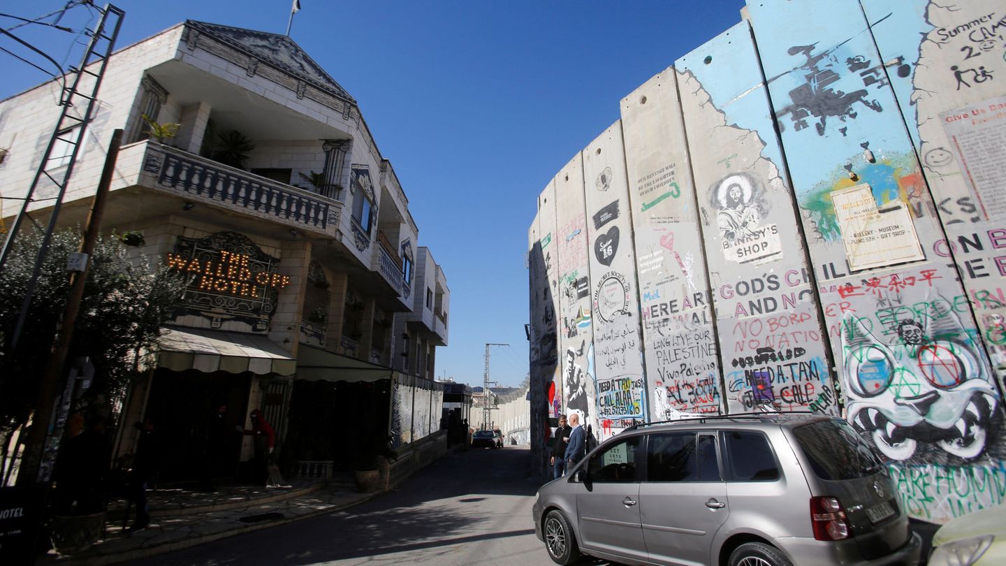 La fachada de 'The Walled Off hotel', el hotel fundado por Banksy, frente a una parte del muro que rodea Belén en Cisjordania. (Reuters)