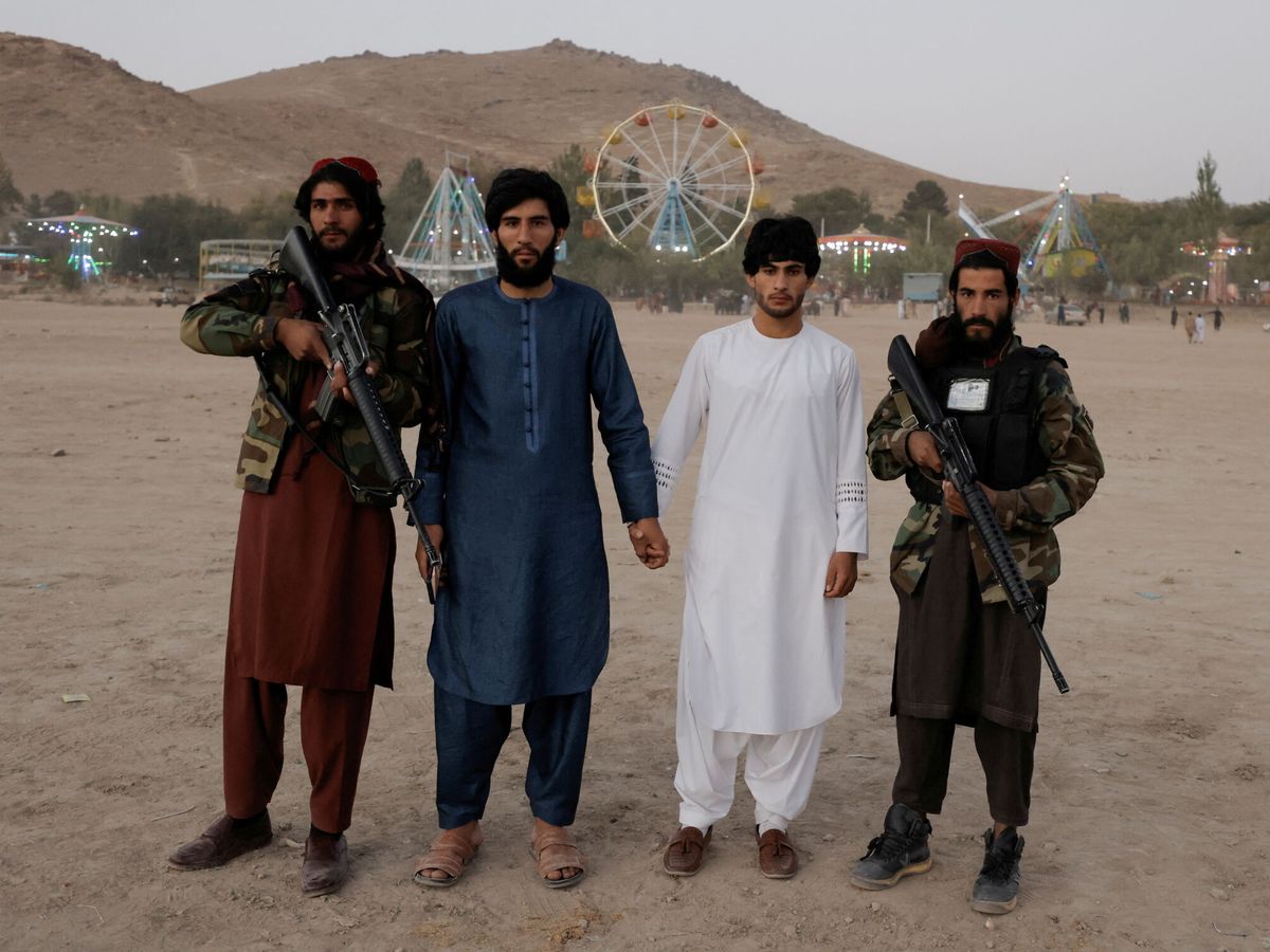 Foto: Los visitantes posan con combatientes talibanes de la provincia de Wardak durante su primera visita a Kabul mientras se toman un día libre para visitar el parque de diversiones en el embalse Qargha de Kabul, en las afueras de Kabul, en octubre de 2021. 