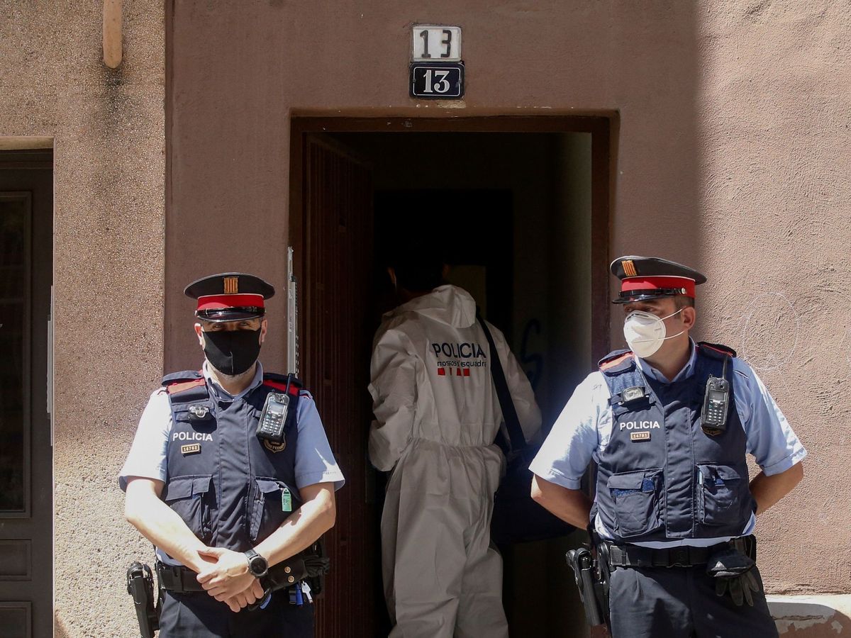 Foto: Los mossos custodian el edificio en el que ha aparecido el cadáver de la mujer. (EFE)