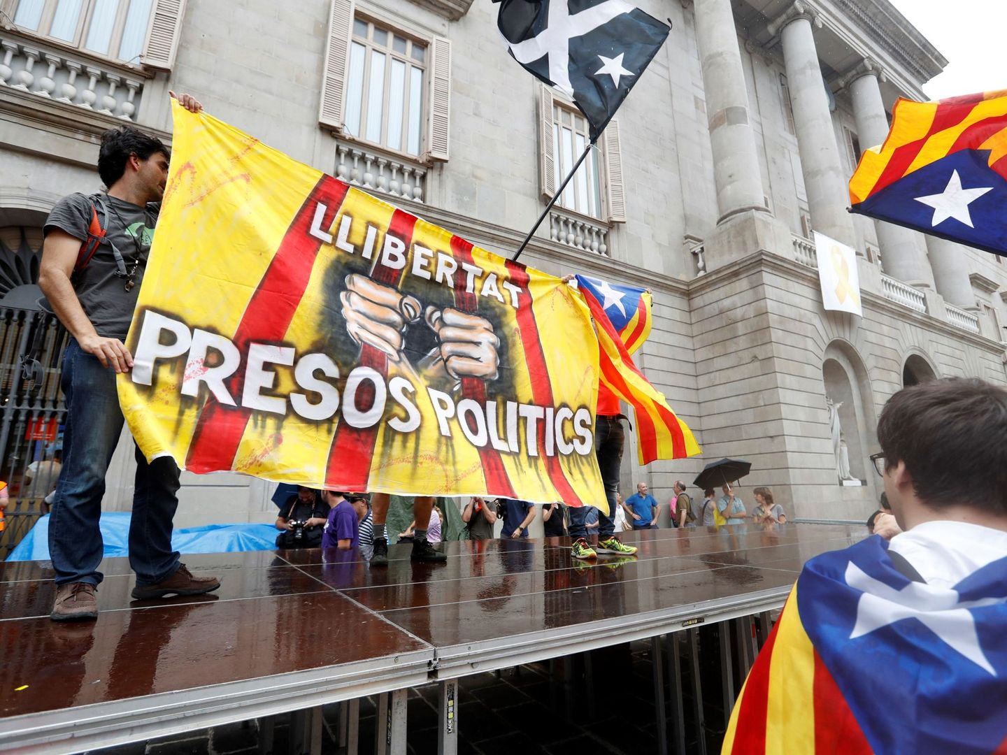 Un grupo de independentistas subidos a una plataforma en la plaza de Sant Jaume. (EFE)