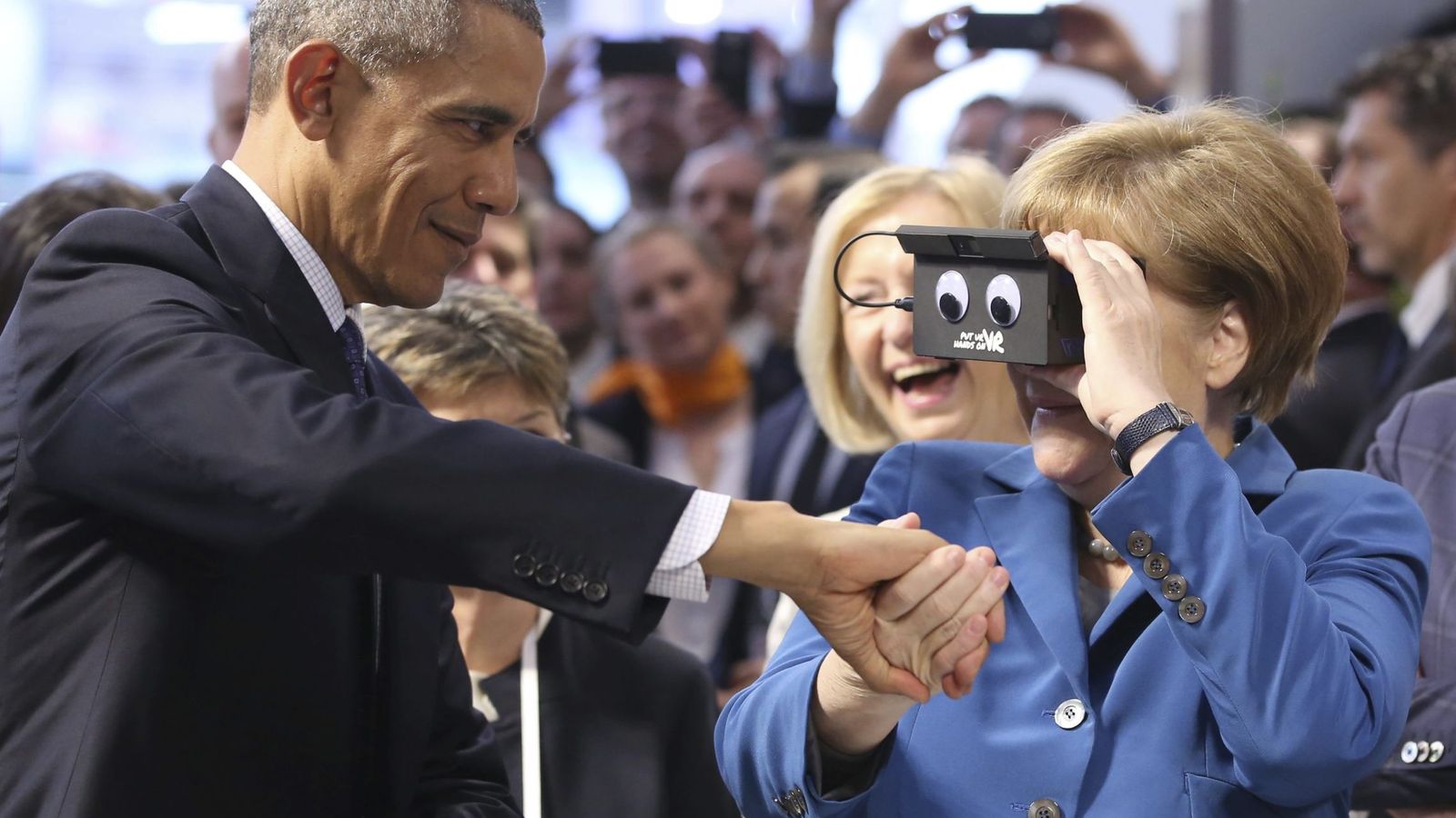 Foto: La canciller Angela Merkel utiliza unas gafas de realidad virtual junto al presidente de Estados Unidos, Barack Obama, en Hannover, el 25 de abril de 2016 (EFE)