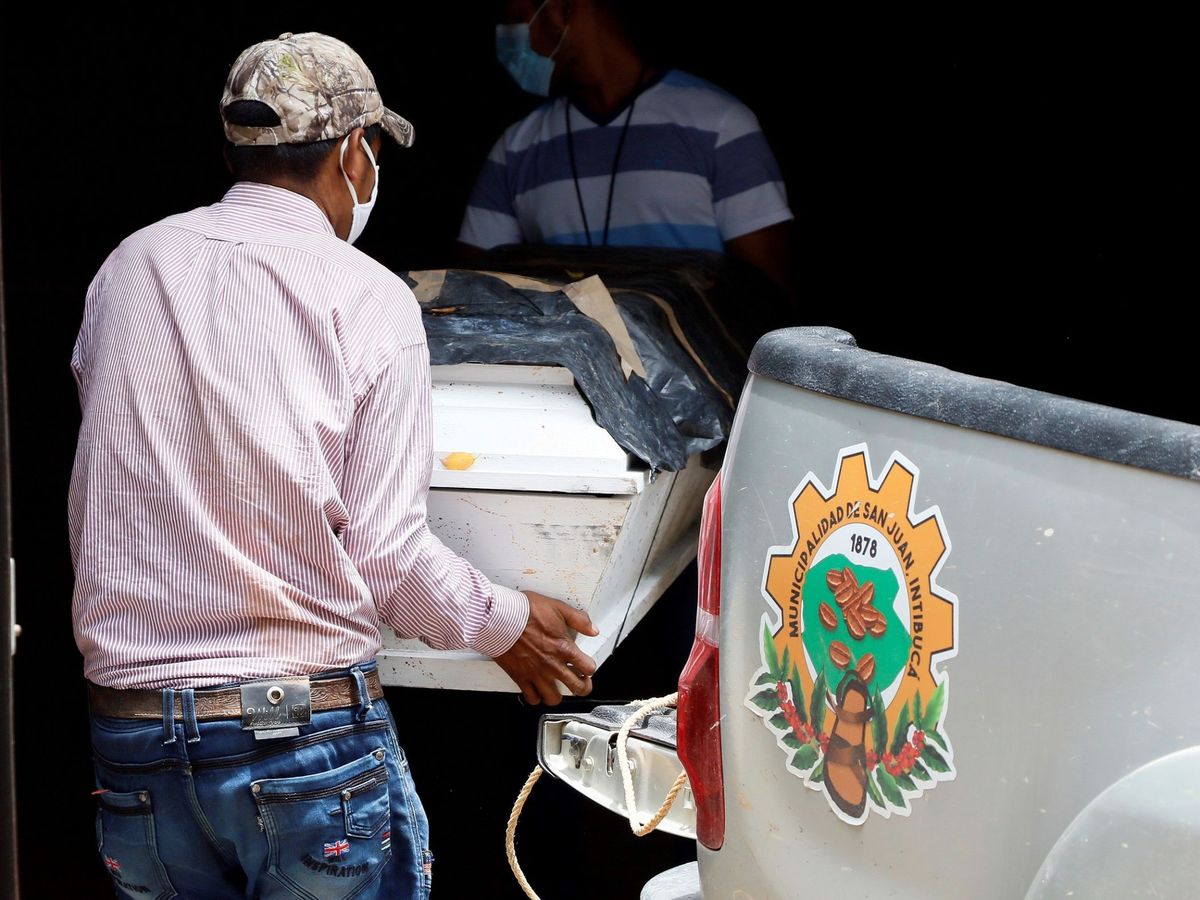 Foto: Dos hombres retiran el cuerpo de un fallecido por coronavirus en Hondura. Foto: EFE Humberto Espinoza