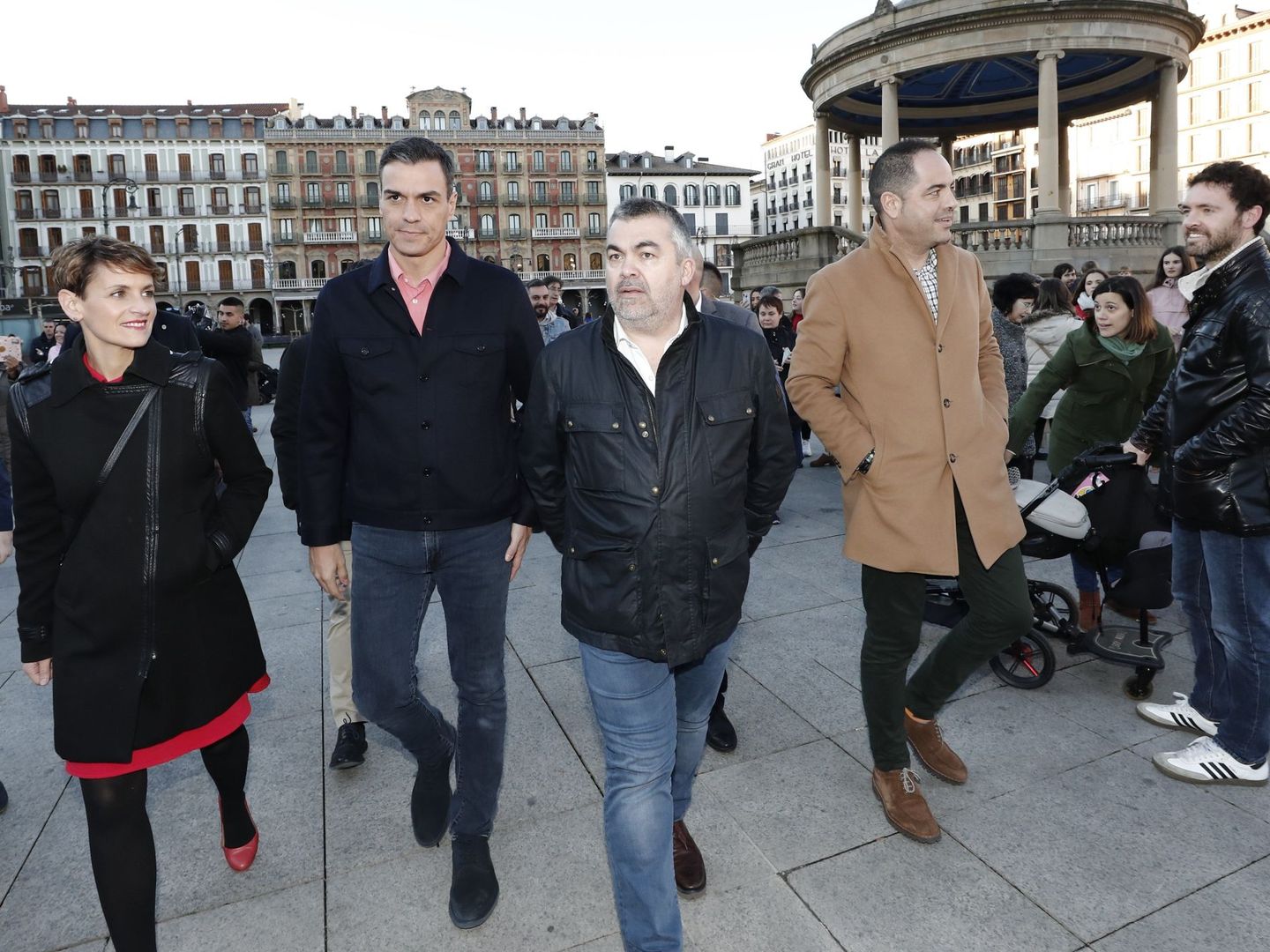El presidente Pedro Sánchez, flanqueado por María Chivite y Santos Cerdán, camina con el secretario de Organización del PSN, Ramón Alzórriz (con abrigo beis), el pasado 15 de marzo en Pamplona. (EFE)