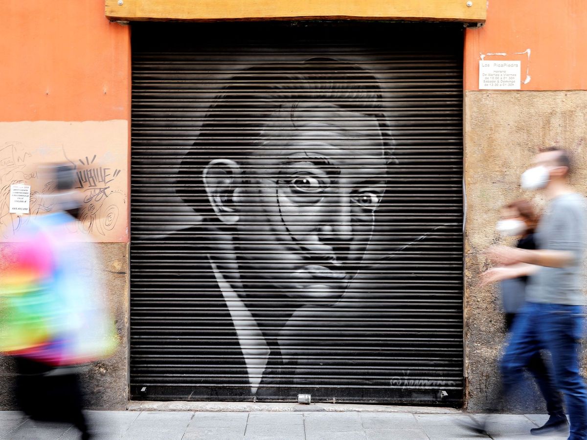 Foto: Varias personas pasan ante un grafiti del pintor Salvador Dalí. (EFE/Manuel Bruque)