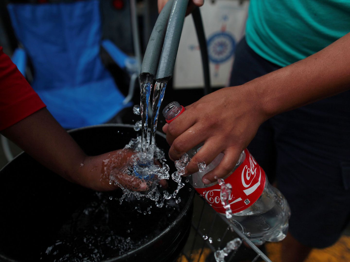 Portorriqueños llenan botellas con agua tras el huracán. (Reuters)