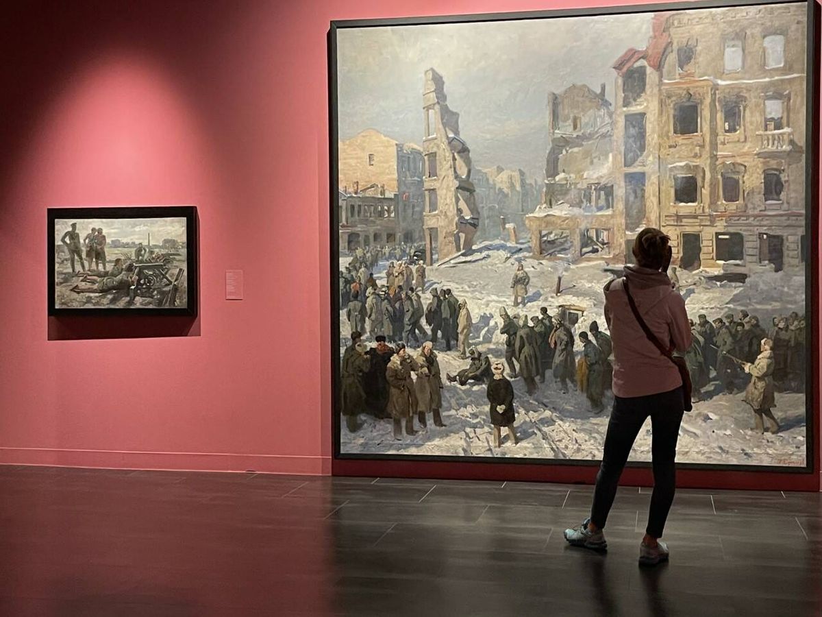 Foto: Una mujer observa uno de los cuadros expuestos en 'Guerra y paz', en el Museo Ruso de Málaga. (A. R.)