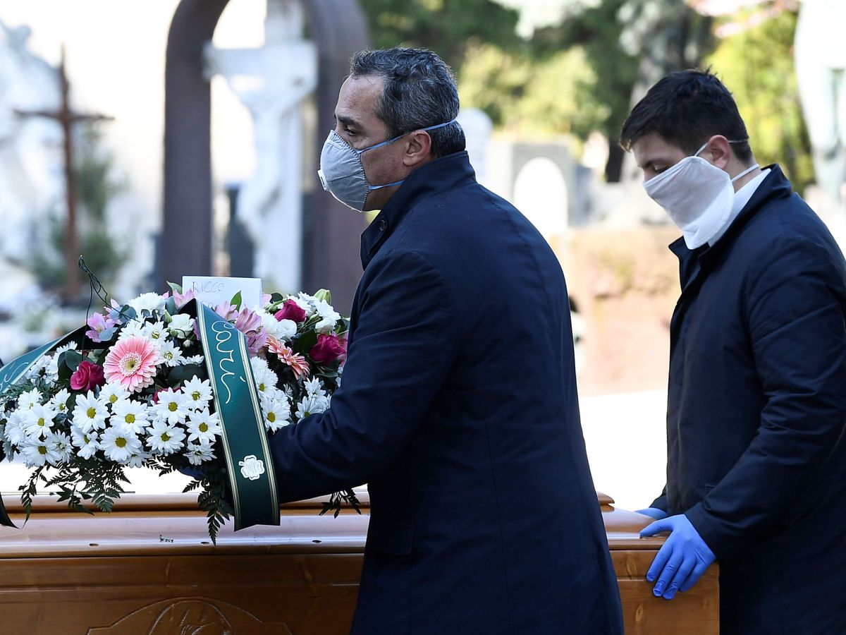 Foto: Trabajadores de la funeraria transportan el ataud de una persona muerta por coronavirus en Bérgamo (Italia) (Reuters)