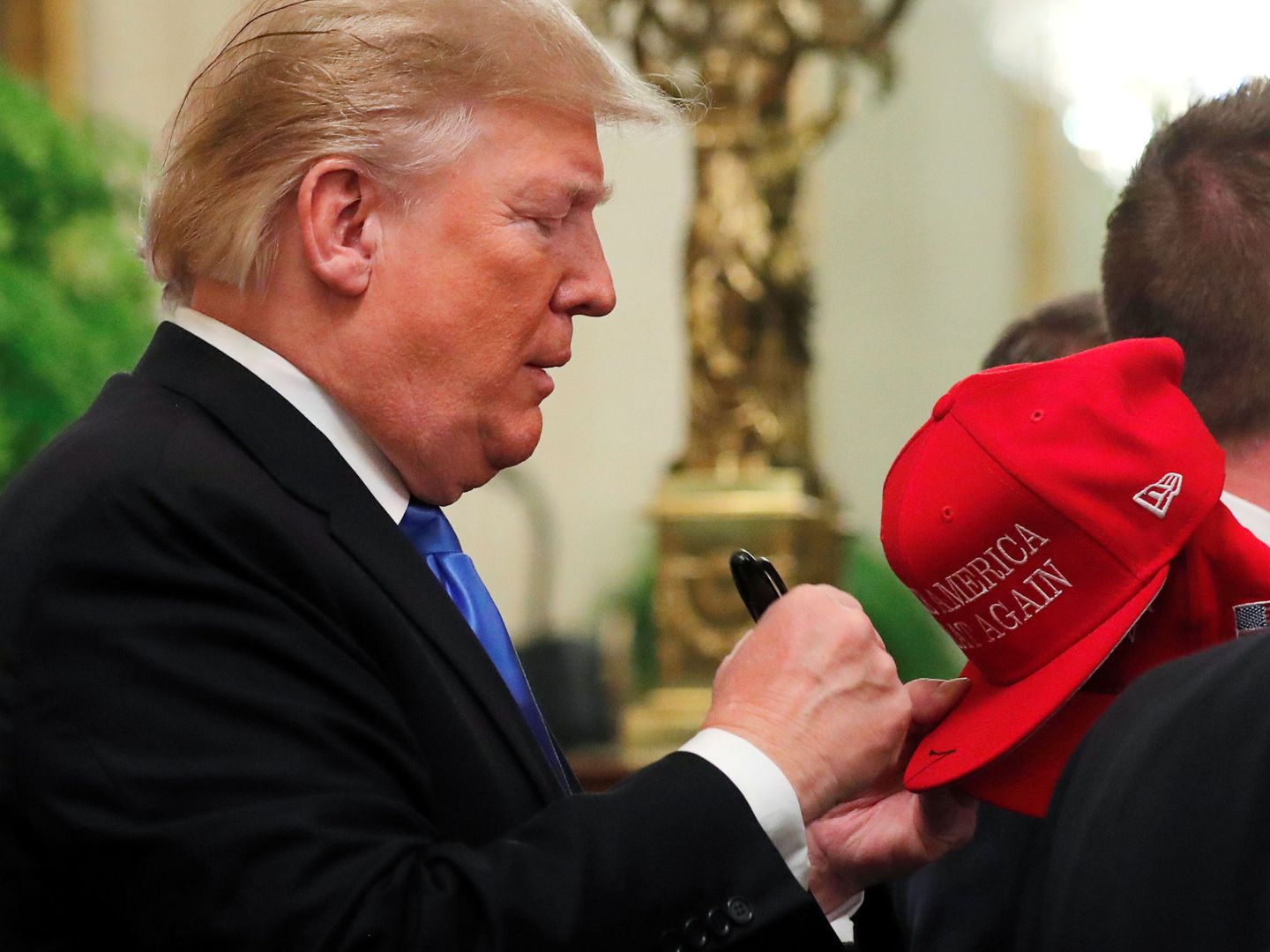 Donald Trump, firmando una gorra con el lema 'Make America Great Again' (Reuters/Carlos Barria)