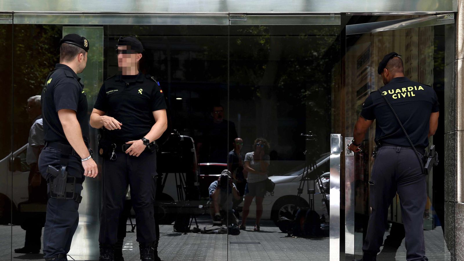 Foto: Agentes de la Guardia Civil, custodiando esta mañana la entrada al edificio de la sede de la consultora Efial en Barcelona. (EFE)