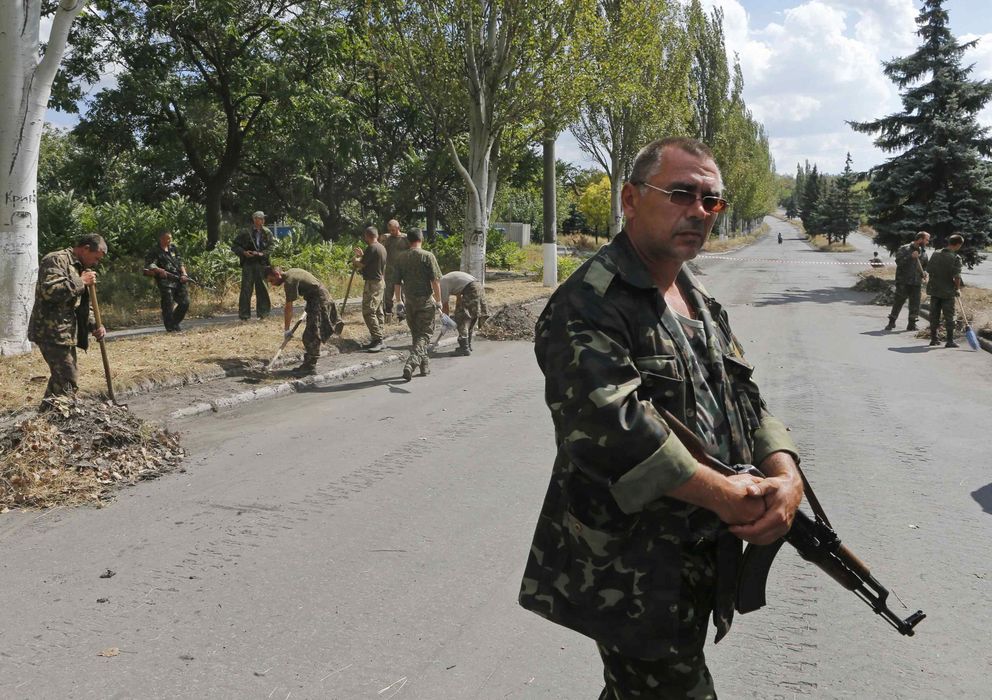 Foto: Soldados ucranianos que han caído en manos de los rebeldes prorrusos limpian una carretera en Snezhnoye, Donéstk. (Reuters)