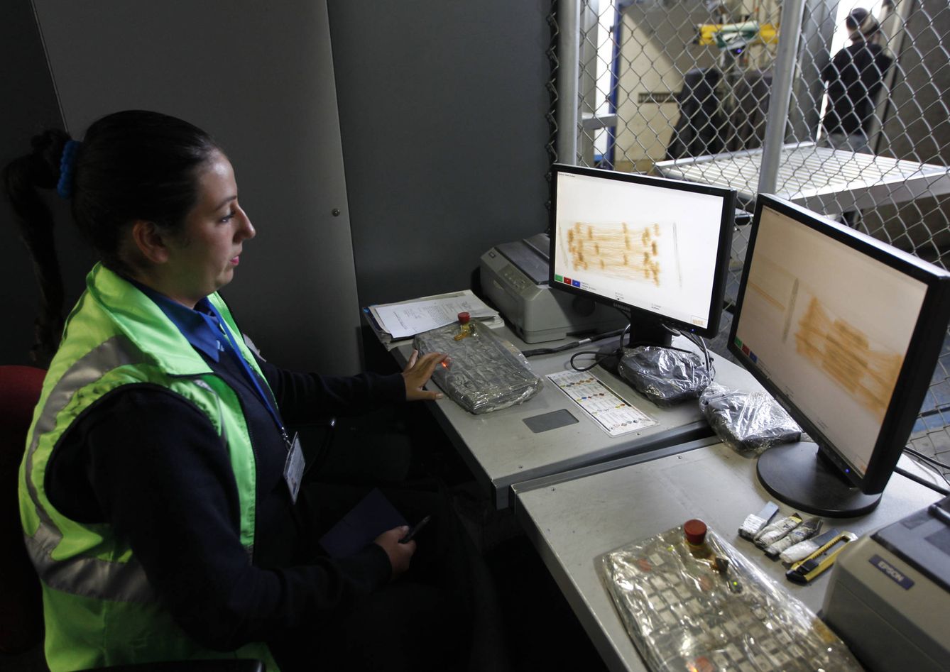 Una empleada de aduanas inspecciona cajas en un aparato de rayos X en el aeropuerto de El Dorado de Bogotá (Reuters)