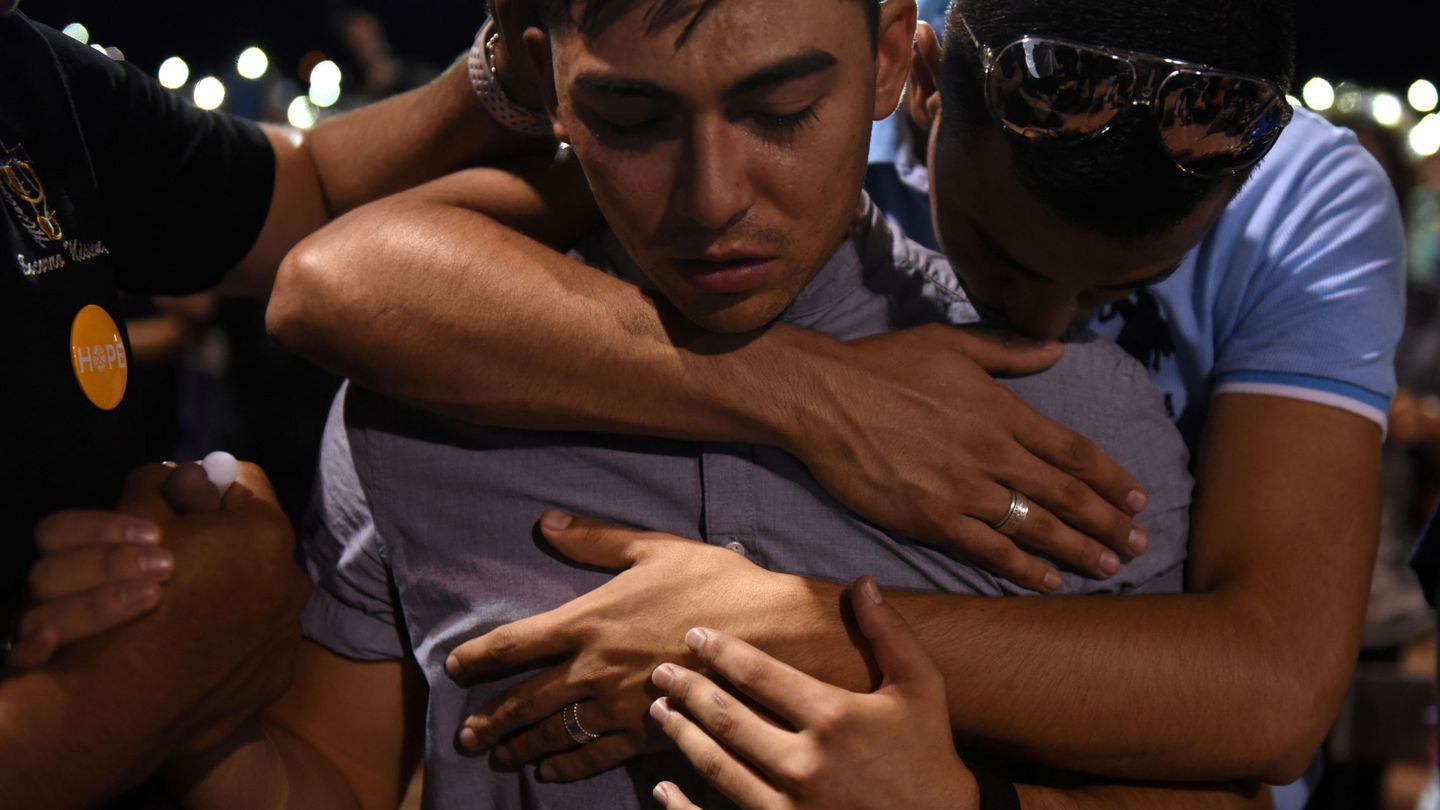 Un grupo de personas se abraza durante la vigilia por el tiroteo en El Paso. (Reuters)