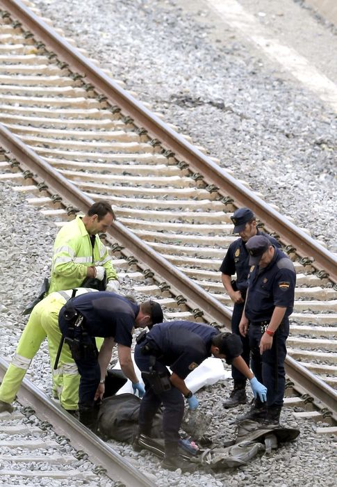 Foto: Operarios retiran lo restos del accidente de tren en Santiago de Compostela. (Efe)