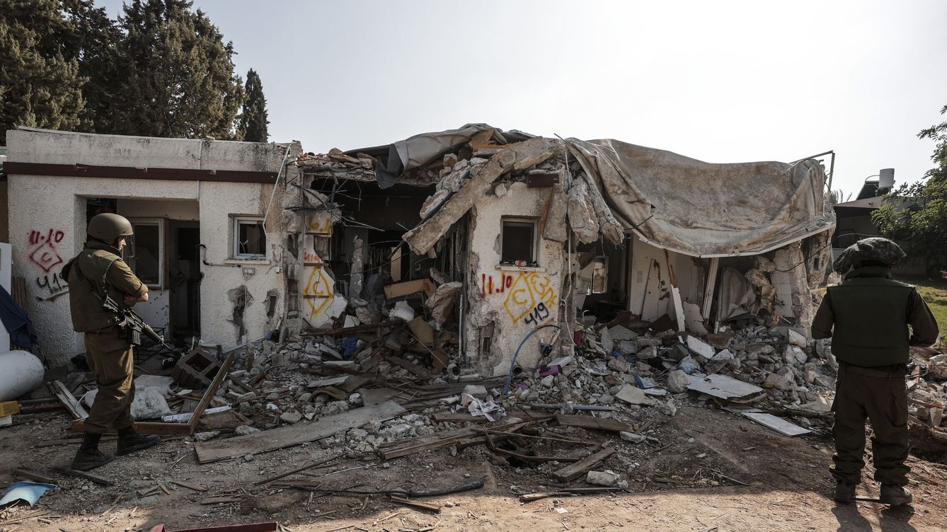 Foto:  Dos soldados israelíes observan una vivienda destruida en el kibutz. (EFE/Manuel Bruque)
