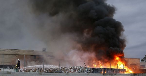 Foto: Los bomberos intentan sofocar las llamas de un aparatoso incendio en una planta de reciclaje de Alicante (Manuel Lorenzo / EFE)