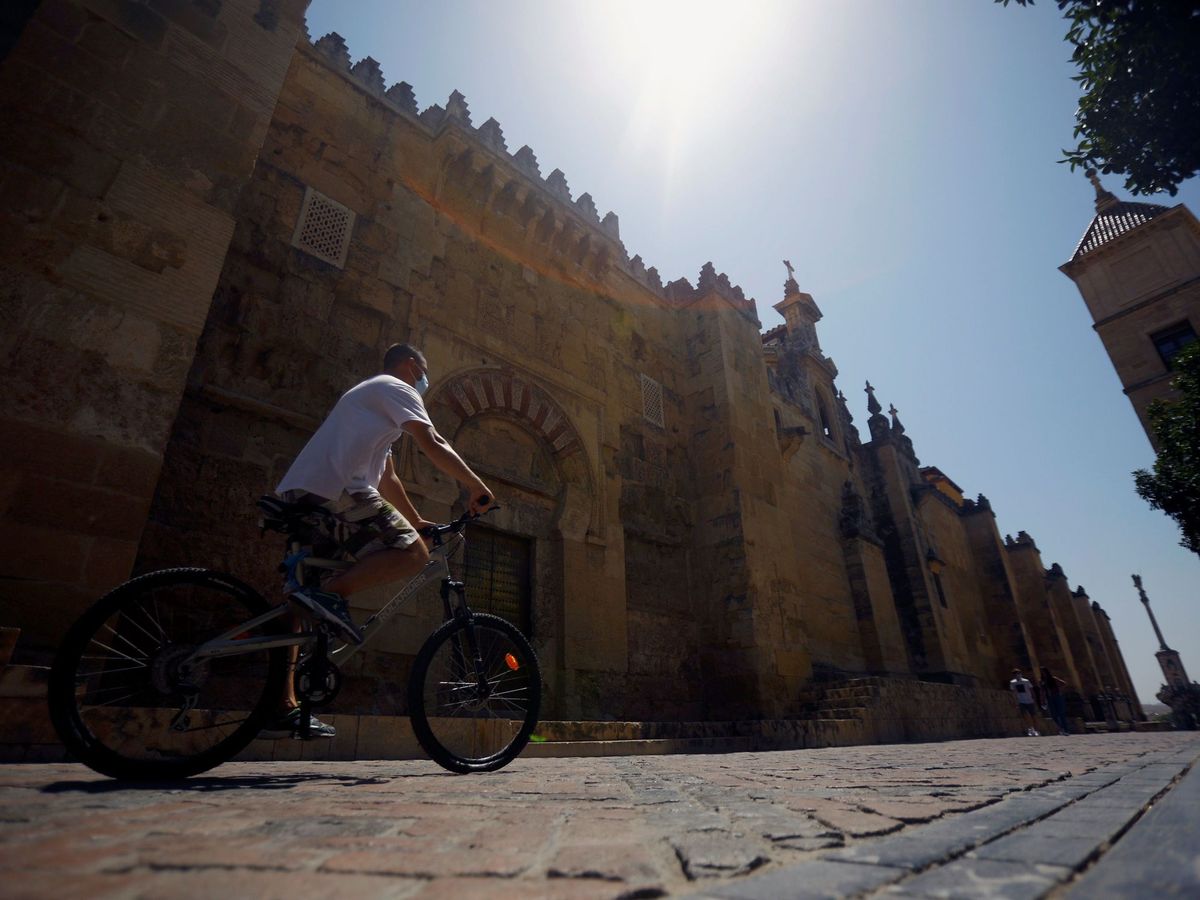 Foto: Un hombre en bicicleta pasa junto la Mezquita - Catedral en Córdoba. (EFE)