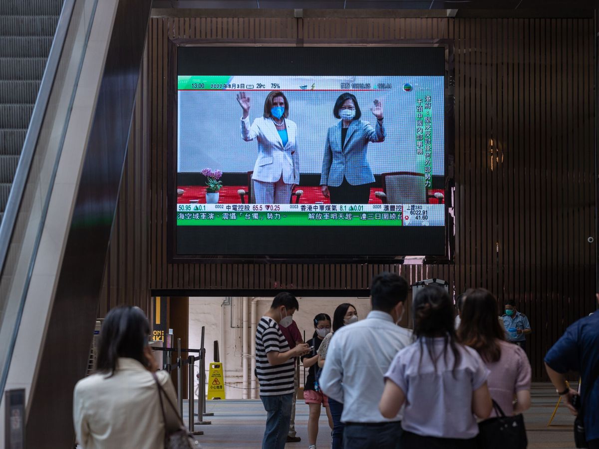 Foto: Varios ciudadanos observan en una pantalla la llegada de Nancy Pelosi a Taiwán. (EFE/EPA/Jerome Favre)