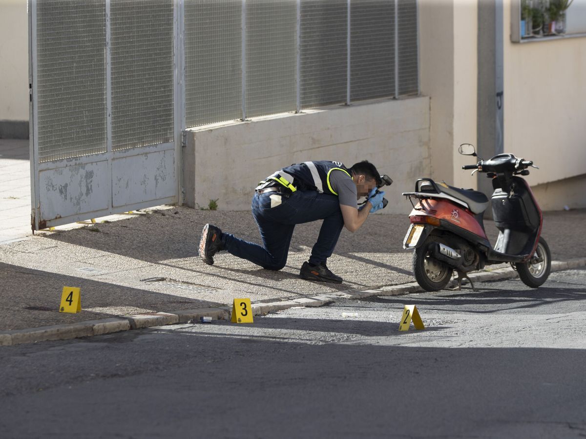 Foto: Un agente fotografía vestigios en el lugar del tiroteo. (EFE/Jorge Zapata)