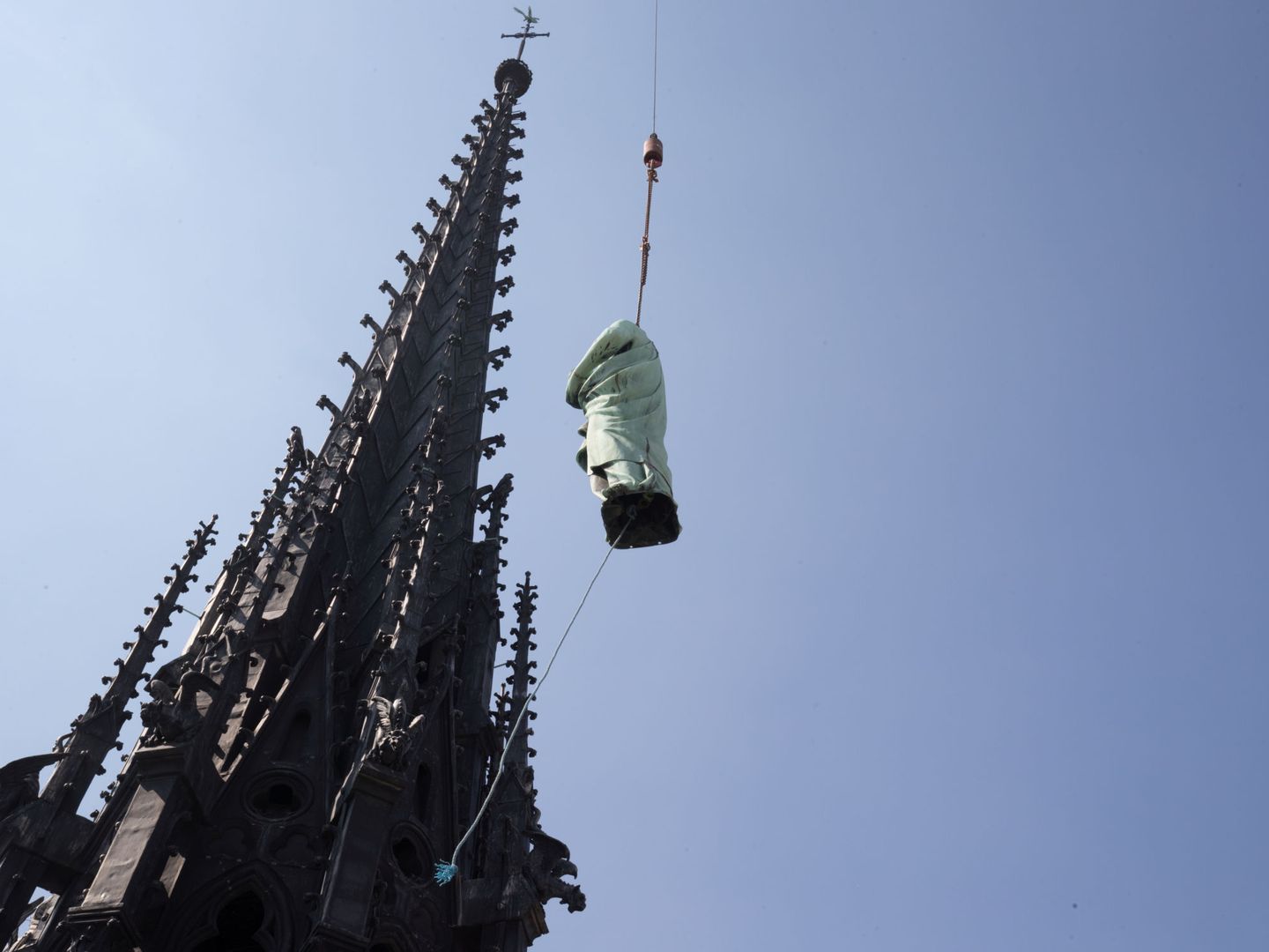 La estatua de San Juan, una de las 16 que adornaban la aguja de Notre-Dame, siendo retirada cuatro días antes del incendio (Reuters)