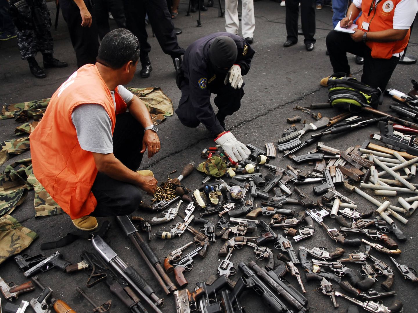 Funcionarios de la OEA recogen armas entregadas por miembros de las maras durante una tregua en 2013. (Reuters)