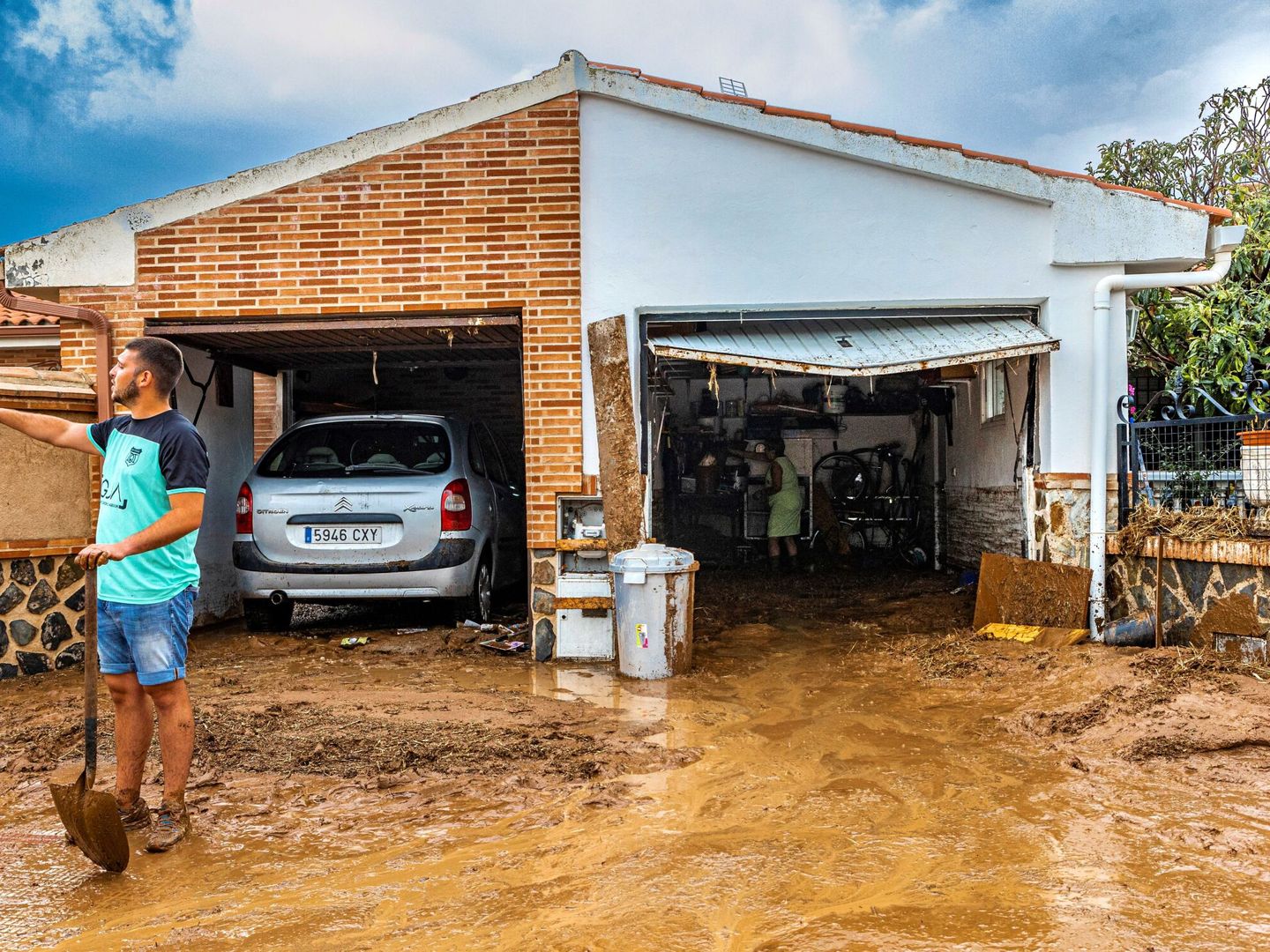 Los vecinos de Cobisa (Toledo) limpian de barro sus viviendas tras la inundación causada por la tormenta. (EFE) 
