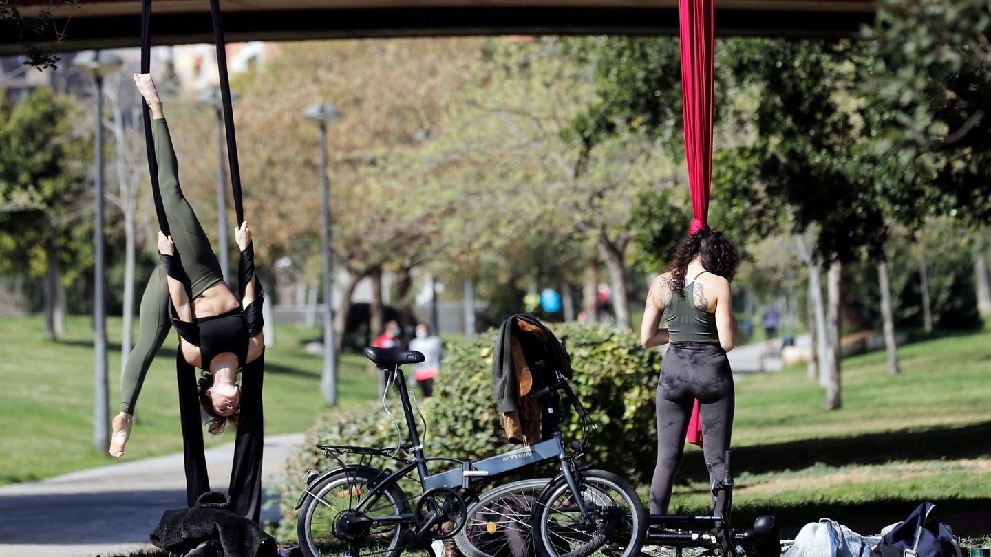 Dos personas realizan ejercicios al aire libre en el Jardín del Túria. (EFE/Manuel Bruque)