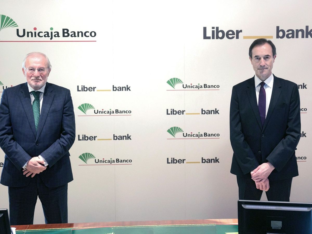 Foto: El presidente de Unicaja, Manuel Azuaga (i), junto con el consejero delegado de Liberbank, Manuel Menéndez. (EFE)