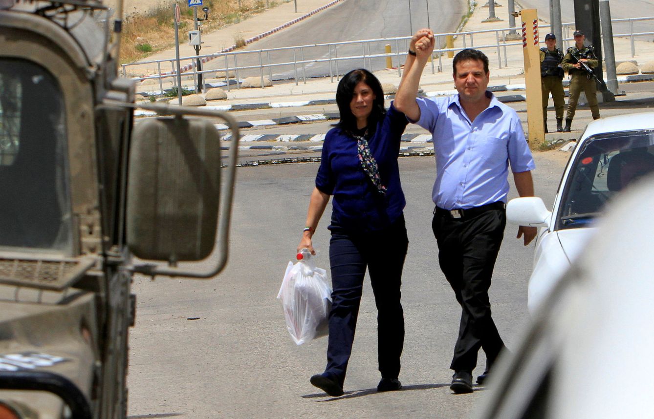 La diputada palestina Khalida Jarrar sostiene la mano del parlamentario árabe-israelí Ayman Odeh tras salir de la cárcel, el 3 de junio de 2016 (Reuters)