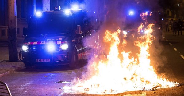 Foto: Un furgón de los Mossos d'Esquadra pasa junto al fuego durante los altercados al finalizar la movilización convocade por la ANC y otras entidades soberanistas. (EFE) 