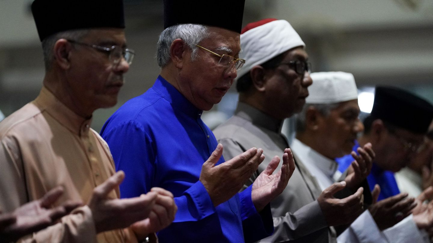 El primer ministro Najib Razak, en el centro, ora con otros fieles en una mezquita en Pekan un día antes de los comicios, el 8 de mayo de 2018. (Reuters)