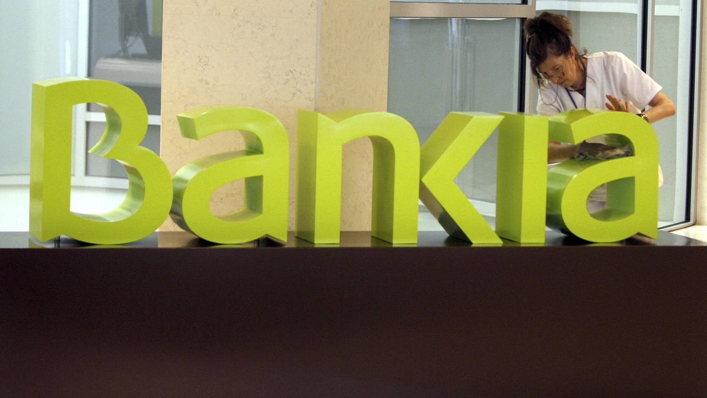 Una operaria limpia el logo de Bankia. (EFE)