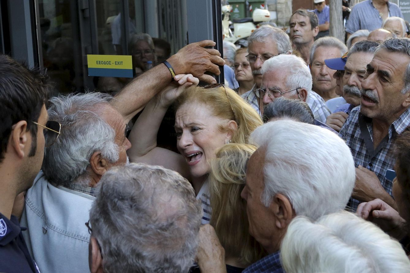 Una pensionista trata de entrar en una sucursal bancaria para cobrar su pensión, en la isla de Creta (Reuters).